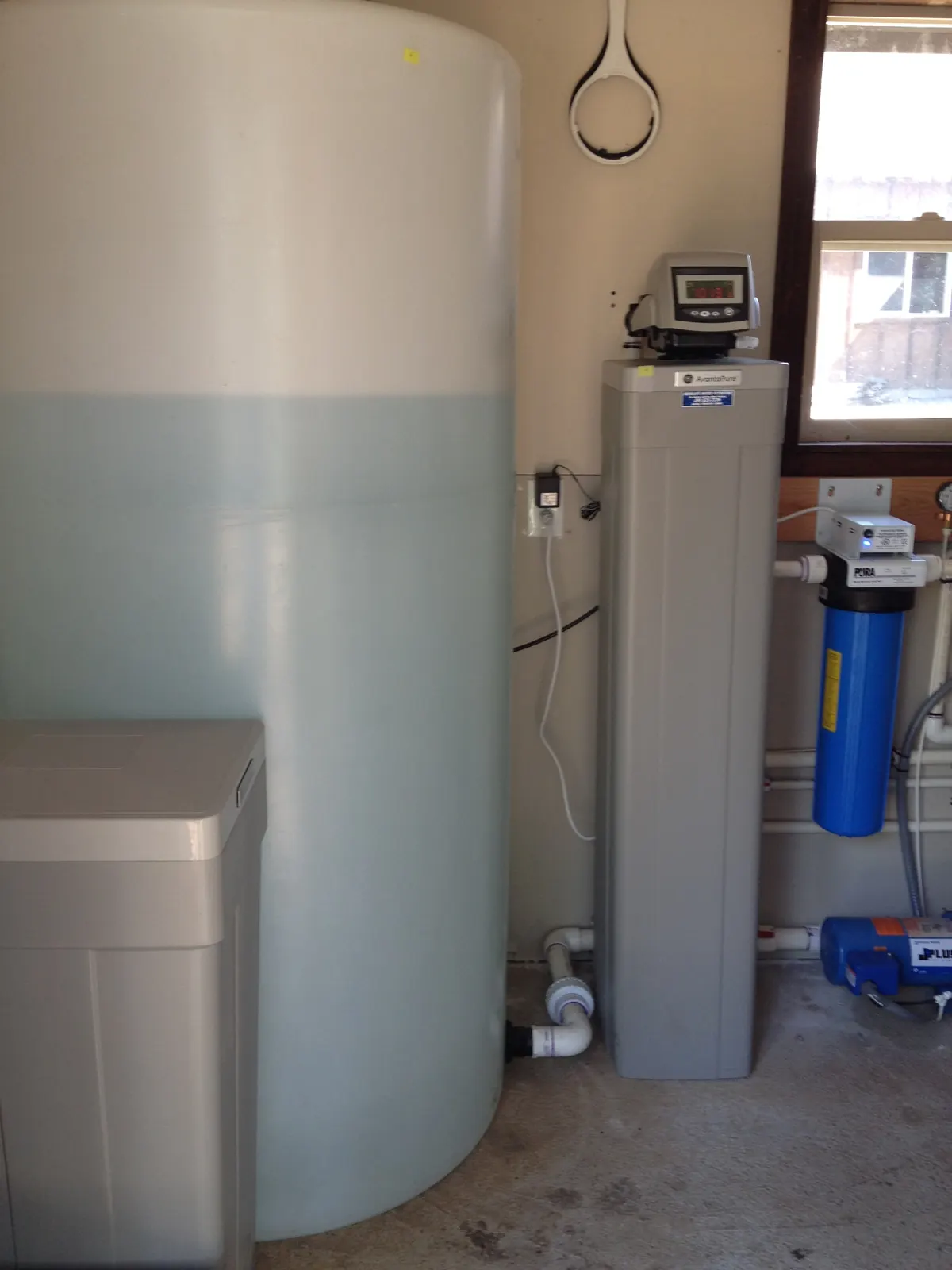 Atmospheric storage tank feeding a softener and point-of-entry filter.